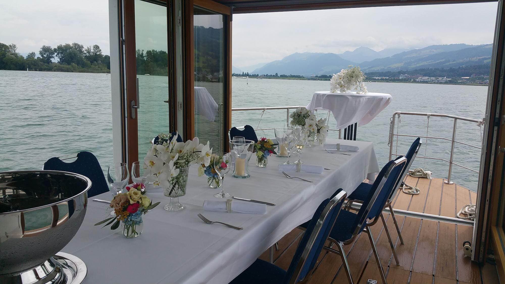 Festlich gedeckter Tisch an Bord mit Blick auf den Zürichsee und die Berge
