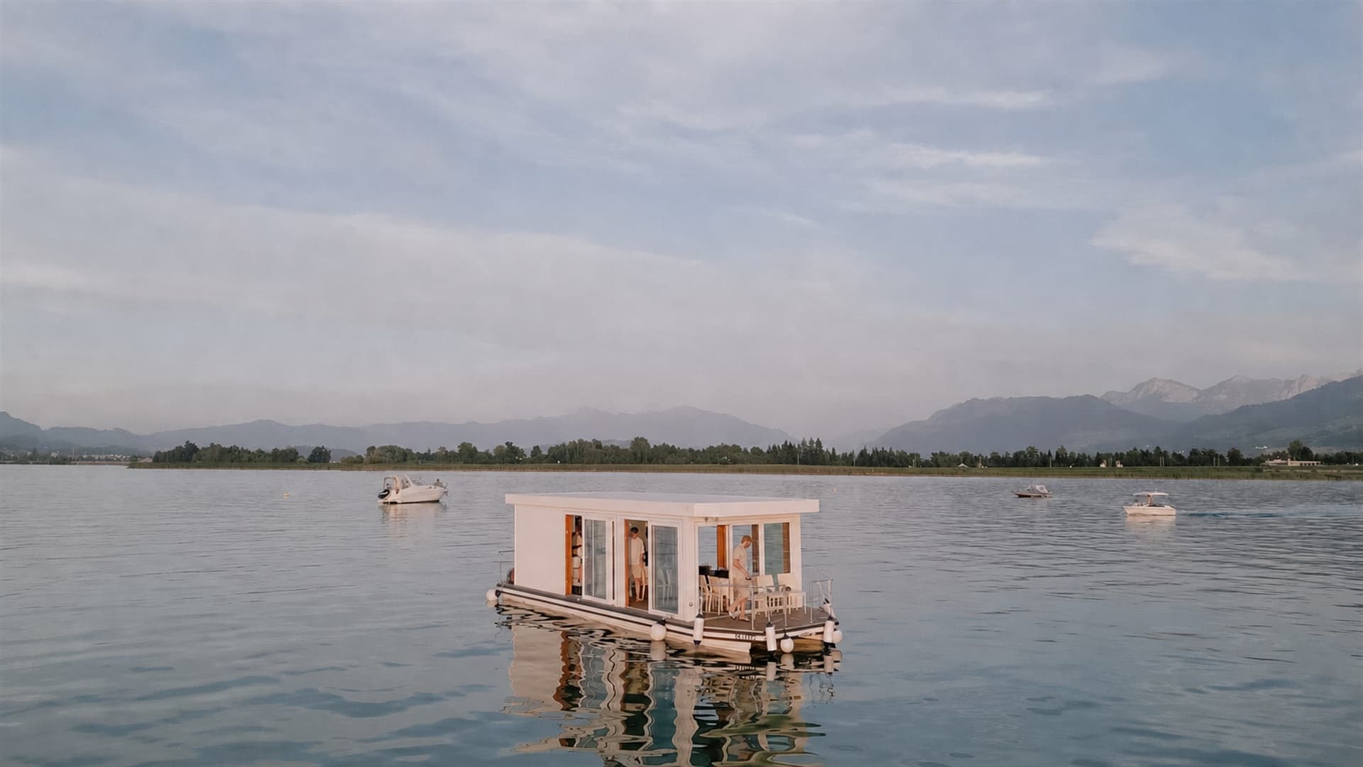 Drohnenaufnahme des Eventflosses bei Sonnenuntergang, spiegelglatter Zürichsee